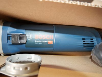 a blue and white electric sander in a cardboard box