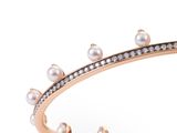 a close up of a bracelet with pearls and diamonds on it