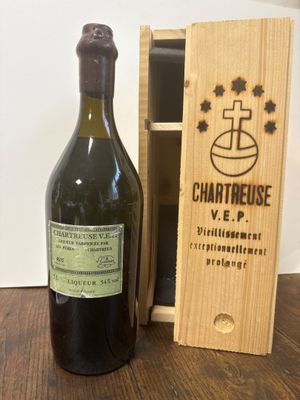 une bouteille de vin posée sur une table à côté d'une caisse en bois