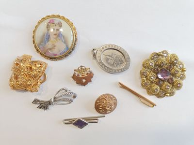 a lot of brooches and pins on the table