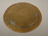 a gold plate on a white table with a white background