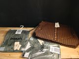 un tas de vêtements posé sur une table, à côté d'une paire de lunettes