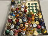 une boîte remplie de capsules de bière de toutes sortes posée sur une table