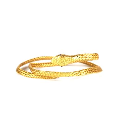 gros plan d'un bracelet en or sur fond blanc