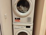 deux lave-linge et un sèche-linge empilés les uns sur les autres