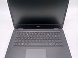 the dell laptop is open on a white surface with a black keyboard