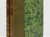 un livre à la couverture verte posé sur une table blanche