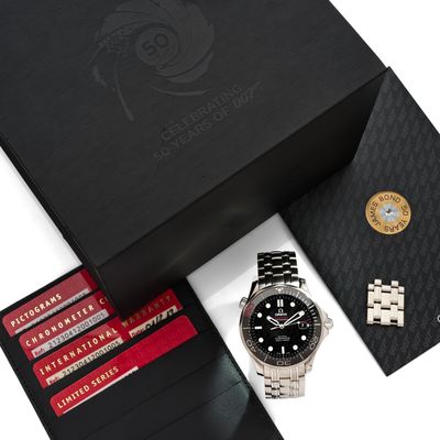 une boîte noire sur laquelle se trouvent une montre, un portefeuille et d'autres objets