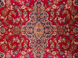 an oriental rug with a red background and a floral design