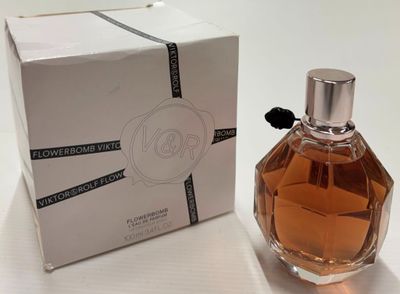 perfume bottle in front of a box on a white surface