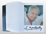 an open book with a picture of a man in a white shirt
