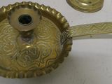 a small brass candle holder with a candle on it