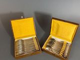 pair of silver plated spoons in a box on a table