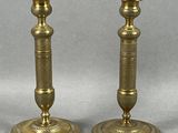 pair of antique brass candlesticks on a grey background