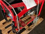 une borne d'incendie rouge posée sur une palette dans un garage