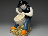 porcelain figurine of a man with a drum and oranges
