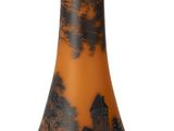 un vase noir et orange posé sur une surface blanche
