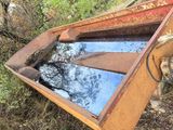 a rusted boat sitting on the ground in the woods