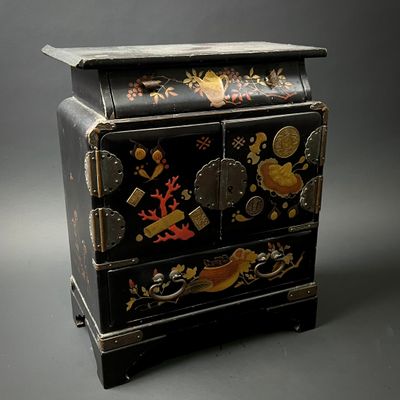 a black chest of drawers with a design on it