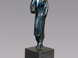 a bronze statue of a woman holding a book on a pedestal