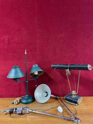 a table with a lamp, a lamp shade, a speaker, and other items on it