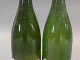 deux bouteilles de vin blanc posées l'une à côté de l'autre sur une table
