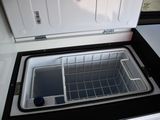 a small freezer with a basket inside of it
