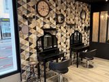 a photo of a hair salon with a clock on the wall