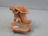 a figurine of a man carrying a turtle on a plate