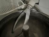 a large metal bowl with a pair of tongs in it