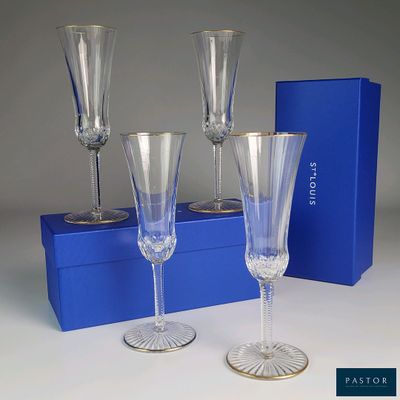 trois verres à vin vides posés à côté d'une boîte bleue sur une table