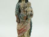 une statue ancienne d'une femme tenant un bébé dans ses bras