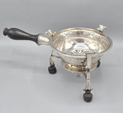 a silverplated bowl with black handles and a wooden handle