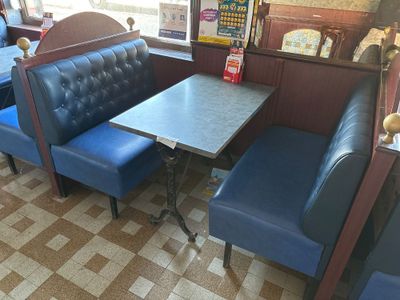a blue booth with a table and two blue chairs