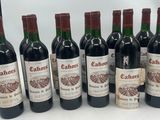 six bouteilles de vin sont alignées sur une table