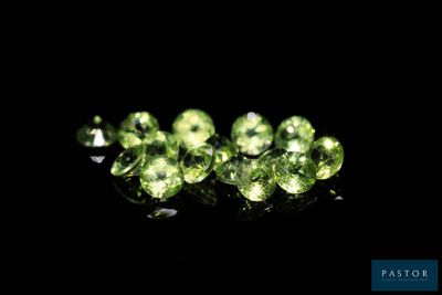 a close up of a group of green gems on a black surface