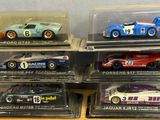 six different model cars in a display case on a table
