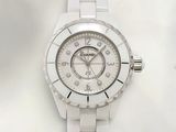 La montre est blanche et présente un cadran orné d'une lunette sertie de diamants.