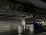 stainless steel shelves with pots and pans on them in a kitchen