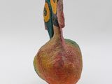 a colorful bird that is sitting on top of a wooden stand