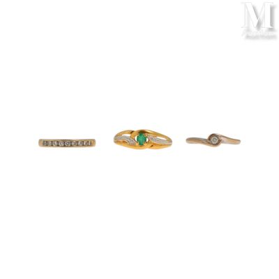three gold rings with emerald stones and diamonds on a white background