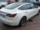 a white tesla car parked in a parking lot