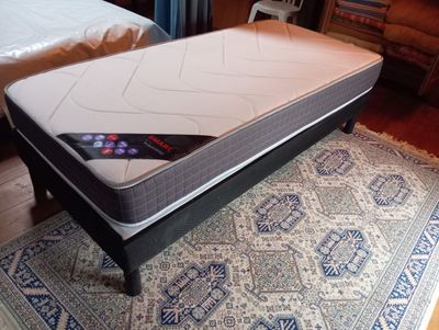 un matelas posé à même le sol, sur un tapis