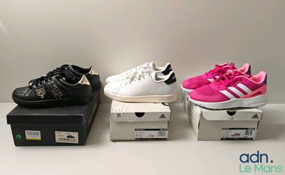 three pairs of shoes are sitting on top of boxes on a table