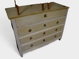 a small chest of drawers with a lamp on top of it