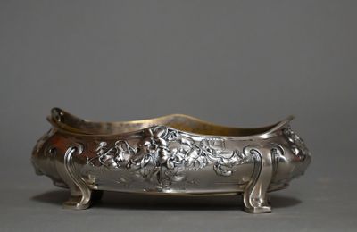 un plat ancien sur pied, en métal argenté, orné d'un motif floral