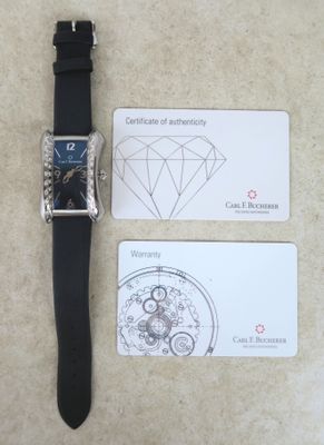 une montre et une carte de visite posées sur une table