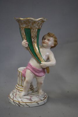 une figurine représentant un garçon tenant un grand vase