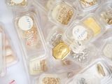 many different types of jewelry in plastic containers on a table