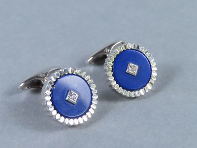 un gros plan sur une paire de boutons de manchette bleus et blancs